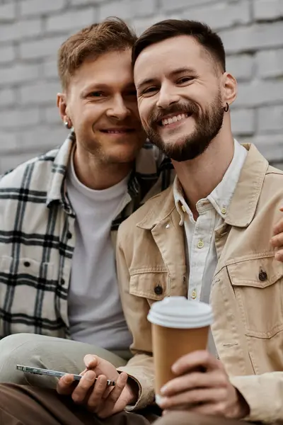 Zwei Männer sitzen eng beieinander, plaudern und genießen gemeinsam Kaffee im Freien. — Stock Photo