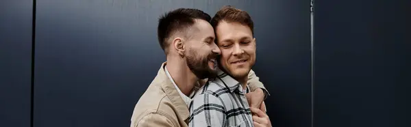 A cheerful gay couple standing close together outdoors. — Stock Photo