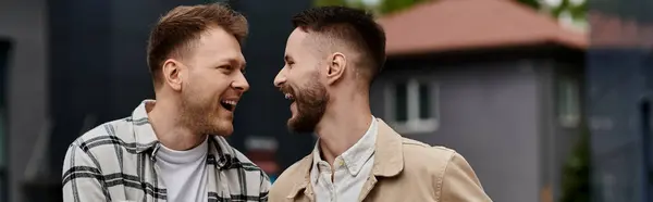 Two men in casual attire, happily standing side by side outdoors. — Stock Photo
