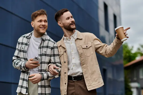 Two men in comfortable attire standing together with coffee cups. — Stock Photo
