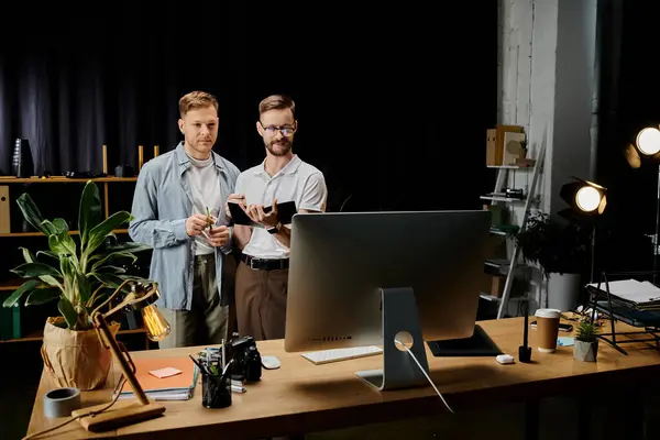 Zwei glückliche Männer, stilvoll gekleidet, arbeiten am Computer am Schreibtisch zusammen. — Stockfoto