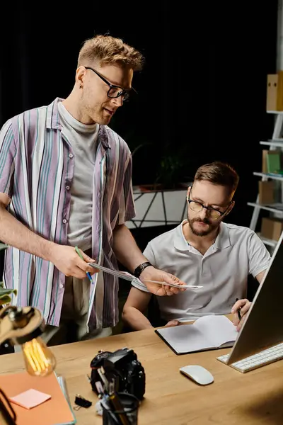 Deux hommes debout, collaborant devant un ordinateur portable. — Photo de stock