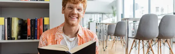 A man exudes happiness while engrossed in reading a book. — Stock Photo