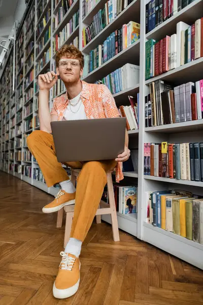 A young man is seated at a desk in front of a laptop, deep in study and concentration. — Stock Photo
