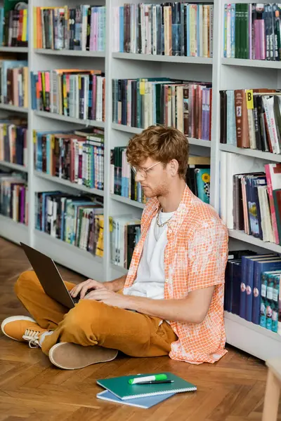 A young man sitting on the floor using a laptop. — Stock Photo
