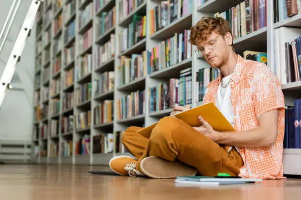 Ein Mann, der auf dem Fußboden versunken ein Buch liest. — Stockfoto