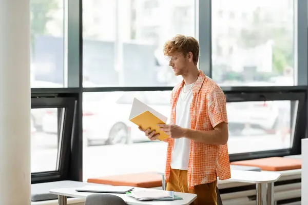 A man holding a book in an office setting. — Stock Photo