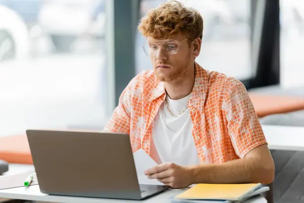 A man engrossed in using a laptop computer at a table. — Stock Photo