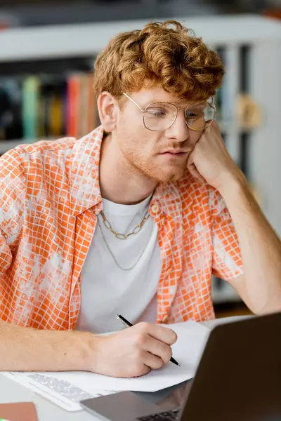 A man engrossed in work on a laptop at a desk. — Stock Photo