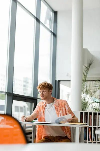 A man focused at a desk in an office setting. — Stock Photo