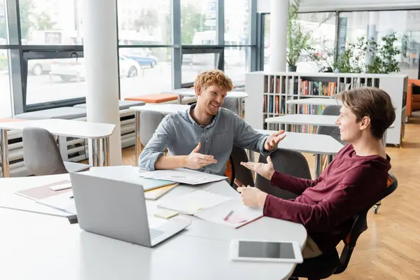 Zwei junge männliche Studenten beim konzentrierten Lernen mit Laptops an einem Tisch. — Stockfoto