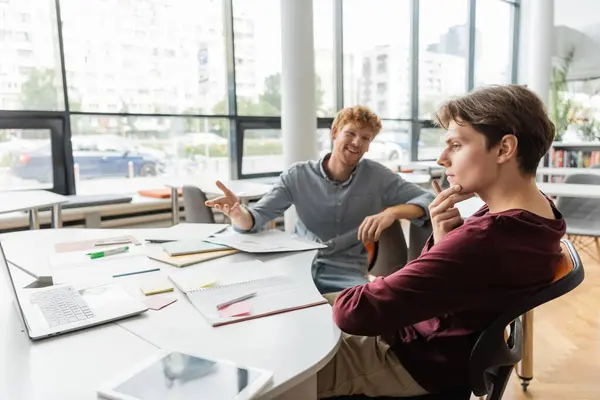 Two men engrossed in a business meeting at a table in a modern office setting. — Stock Photo