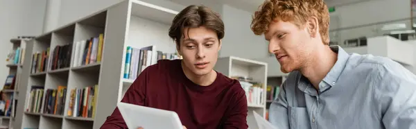 Two male students engrossed in studying together on a computer screen. — Stock Photo