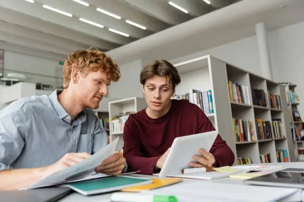 Two young men engage in studying together using a tablet. — Stock Photo