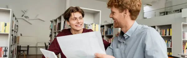 Two male students deeply engrossed in studying a document. — Stock Photo
