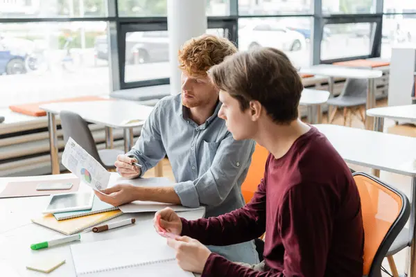 Two male students deeply focused on their studies at a table. — Stock Photo