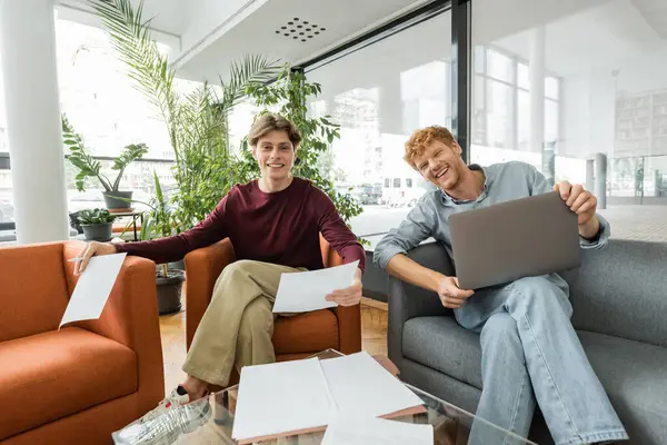 A pair of individuals sitting on top of a couch. — Stock Photo