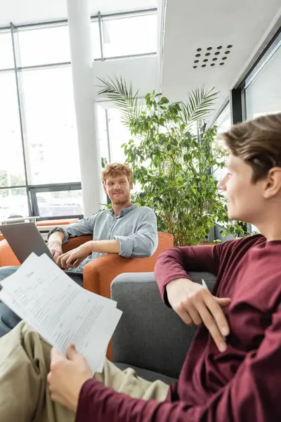 Group of friends sitting together in a warm and welcoming library engaged in conversation and relaxation. — Stock Photo