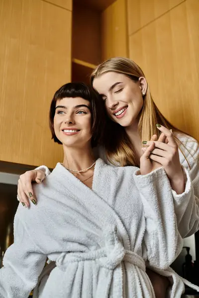 A young lesbian couple in bath robes standing side by side, reflecting intimacy and connection. — Stock Photo
