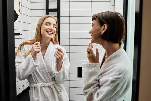 A young women in a bathrobe standing in a hotel bathroom. — Stock Photo