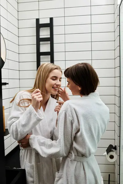 Um jovem casal lésbico fica em uma casa de banho do hotel — Fotografia de Stock