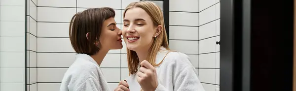 Young lesbian couple in bath robes standing together, sharing a loving and intimate moment. — Stock Photo