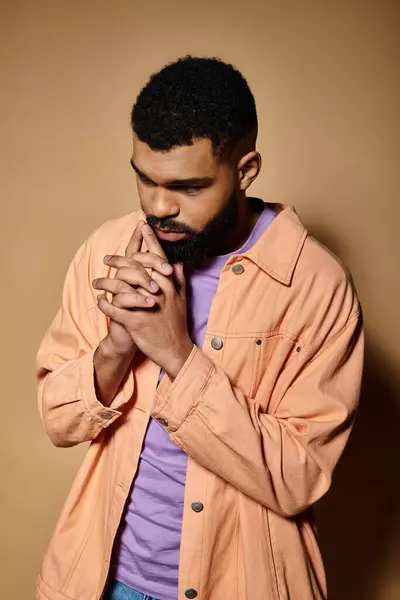 A handsome African American man in fashionable attire is deep in prayer gesture. — Stock Photo