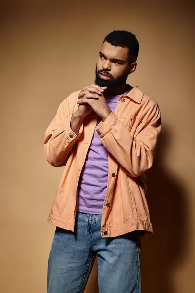 Fashionable African American man poses against a striking brown wall. — Stock Photo