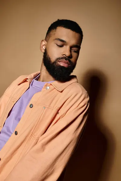 Handsome African American man in orange shirt striking a pose. — Stock Photo