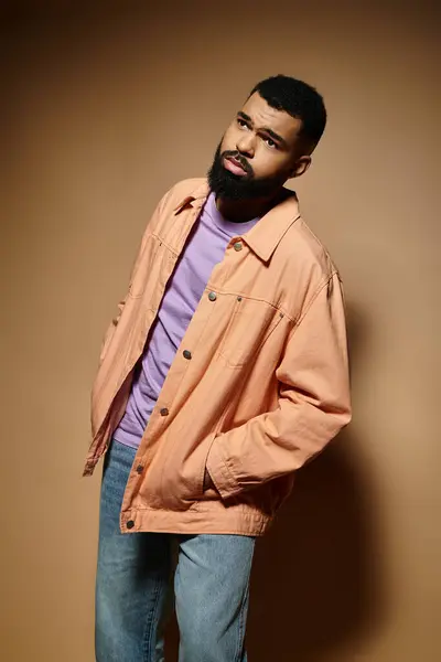 Handsome African American man with beard standing confidently in fashionable attire against vibrant backdrop. — Stock Photo