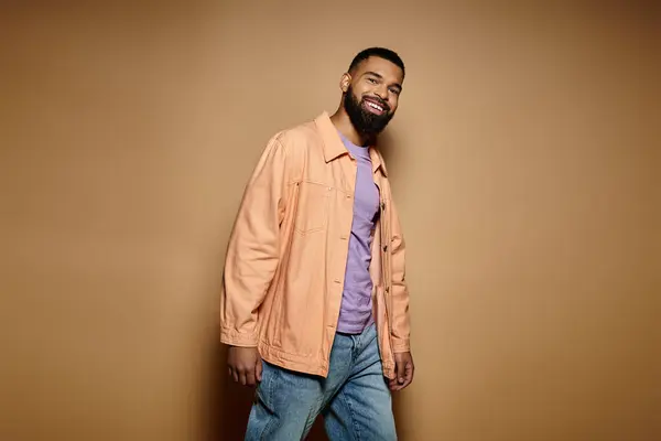 Handsome African American man in fashionable attire standing in front of a vibrant wall. — Stock Photo