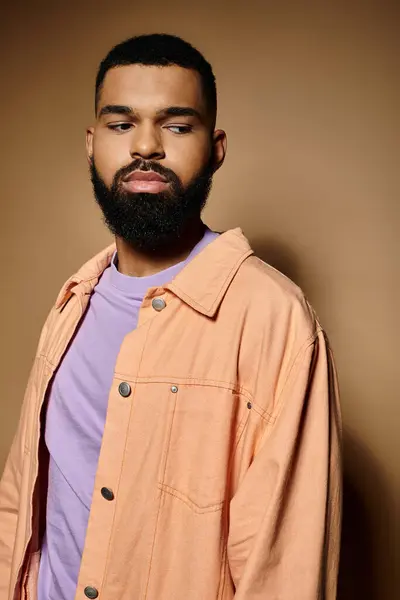 Handsome African American man with beard standing in front of colorful backdrop. — Stock Photo