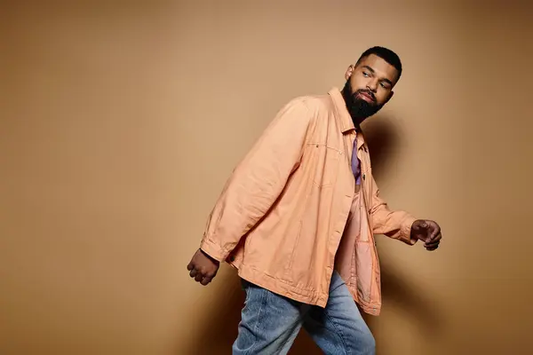 A handsome African American man in fashionable attire standing confidently in front of a vibrant wall. — Stock Photo
