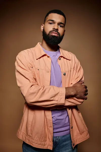 A fashionable African American man with a beard looking stylish in a pink shirt. — Stock Photo