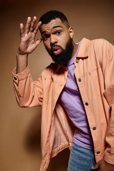 Handsome African American man with a beard posing in a pink shirt on a vibrant backdrop. — Stock Photo