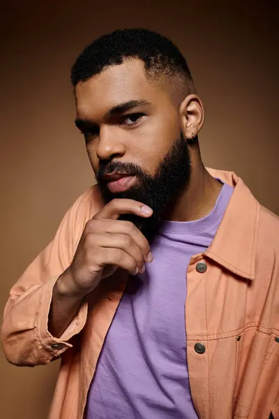 Handsome African American man with beard striking a pose in fashionable attire against vibrant backdrop. — Stock Photo