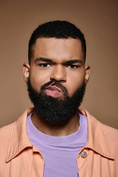 A stylish African American man with a beard captivates with his intense stare. — Stock Photo