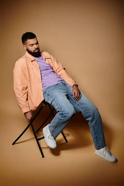 Handsome African American man sitting on chair. — Stock Photo