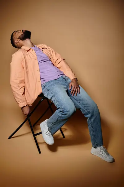 Um homem afro-americano elegante relaxando em um ambiente vibrante com os olhos fechados. — Fotografia de Stock