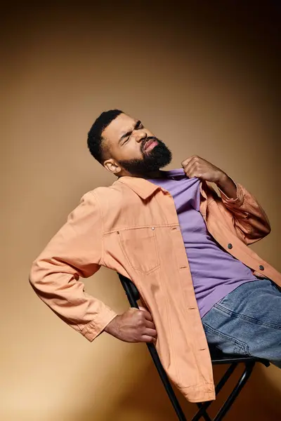 Handsome man in fashionable attire sitting on chair. — Stock Photo