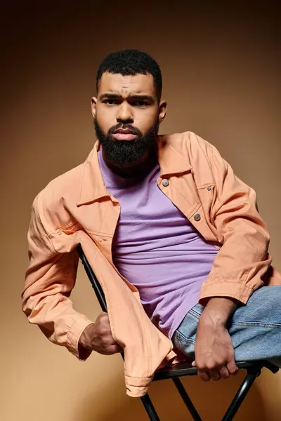Handsome African American man with a beard sitting comfortably in a chair. — Stock Photo