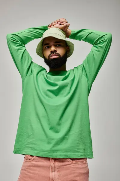 Handsome African American man in fashionable attire posing on a vibrant backdrop. — Stock Photo