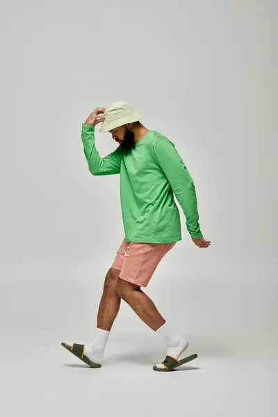 Красивий афроамериканський чоловік в модному вбранні позує на яскравому тлі. — стокове фото