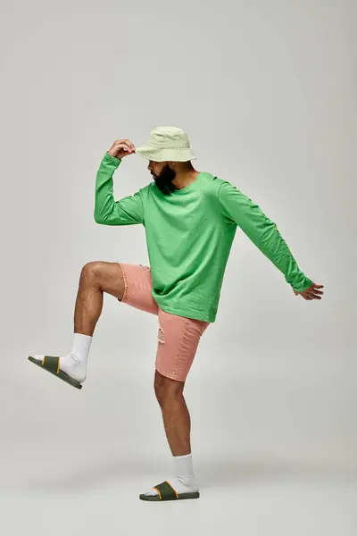 Uomo afroamericano in camicia verde alla moda e pantaloncini rosa colpisce una posa. — Foto stock