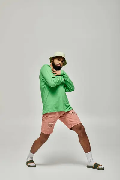 Handsome man poses in trendy attire against vibrant backdrop. — Stock Photo