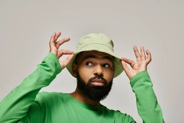 Handsome African American man with beard posing in fashionable attire against vibrant backdrop. — Stock Photo