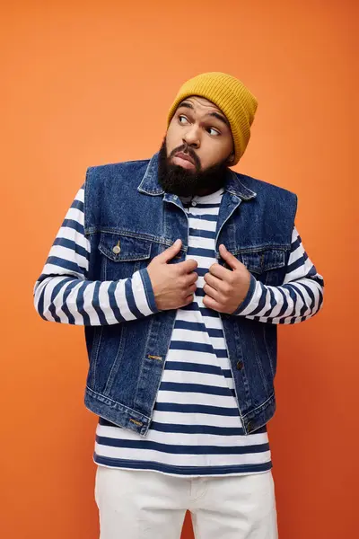 Handsome African American man in denim jacket and striped shirt in a vibrant setting. — Stock Photo