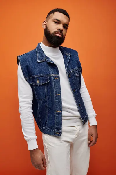 African American man showcasing denim vest on vivid backdrop. — Stock Photo