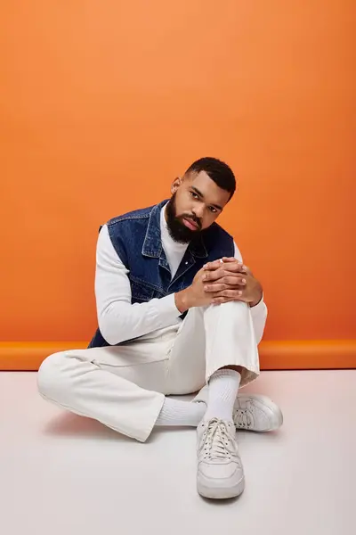 African American man sits gracefully with hands clasped in deep thought. — Stock Photo