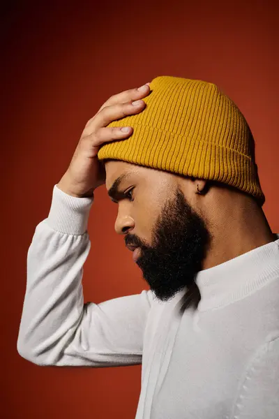 Hombre afroamericano guapo en traje de moda posando con sombrero amarillo. - foto de stock
